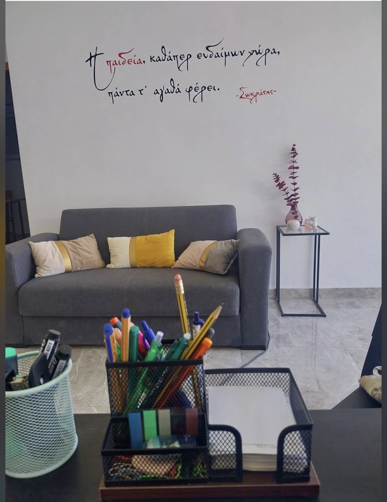 Χώρος υποδοχής με καναπέ και ρητό του Σωκράτη